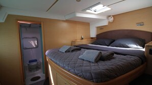A compact bedroom with a bed, bedside table, and a skylight. - Sun-Kissed Sailing Adventure in Islas Sarónicas (Alimos)