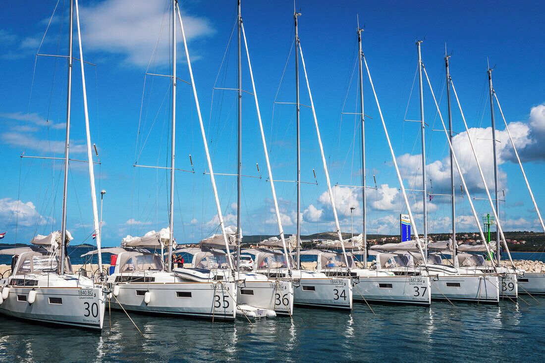 A marina with multiple sailboats docked.