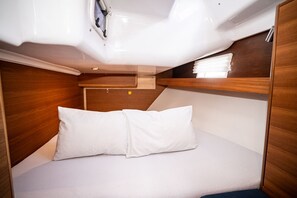 A compact, well-lit cabin with a bunk bed and a small seating area. - Sibenik Sun-soaked Sailing: A Luxurious Croatian Voyage (Pirovac)