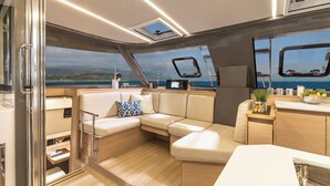A modern interior with a sofa, a small table, and a view of the sea.