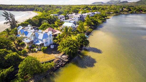 A coastal resort with multiple buildings, a beach, and a river.