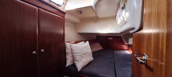 A compact interior with a bed, a wardrobe, and a small seating area.