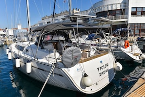 A white yacht docked at a marina with 'TICIZA ZADAR' written on the bow.