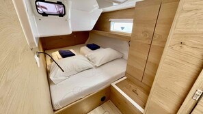 Ein gemütlicher, hölzerner Innenraum mit Etagenbett, kleinem Fenster und Steckdose.