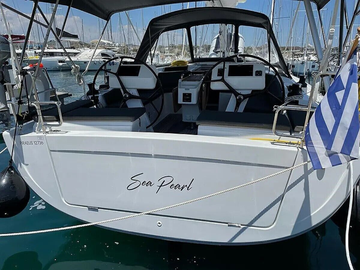 A boat named 'Sea Pearl' docked at a marina with other boats visible in the background.
