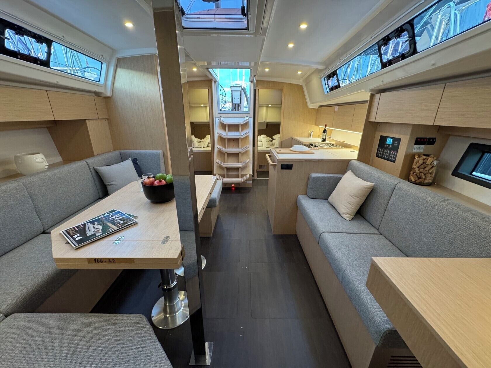 A compact, modern interior with a dining area, sofa, and kitchenette.
