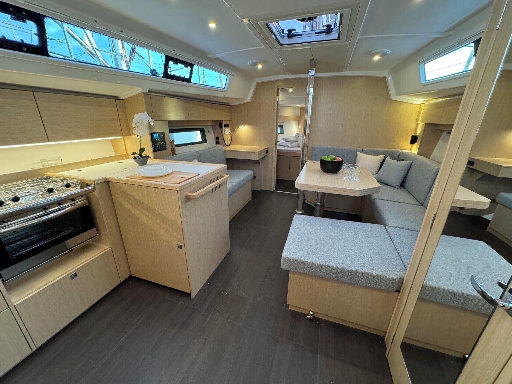 Een compact, goed verlicht interieur met een kitchenette, zithoek en een eettafeltje.