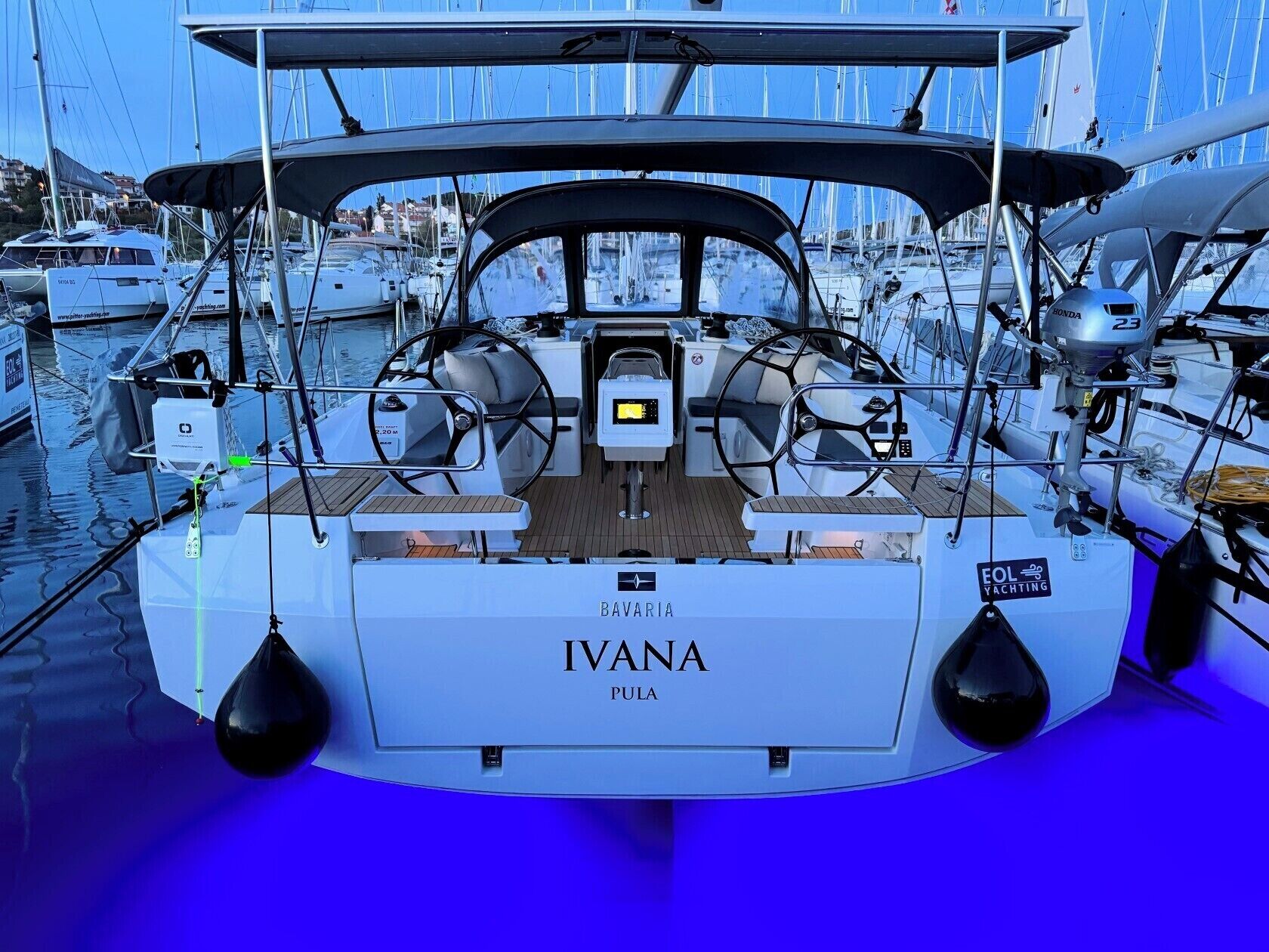Ein Boot namens 'BAVARIA IVANA' mit Steuerrad, Bedienfeld und Sitzbereich.