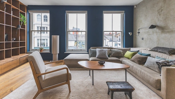 A modern living room with a sofa, armchair, coffee table, and a bookshelf. - Modern Designer Townhouse, Earl's Court (London)