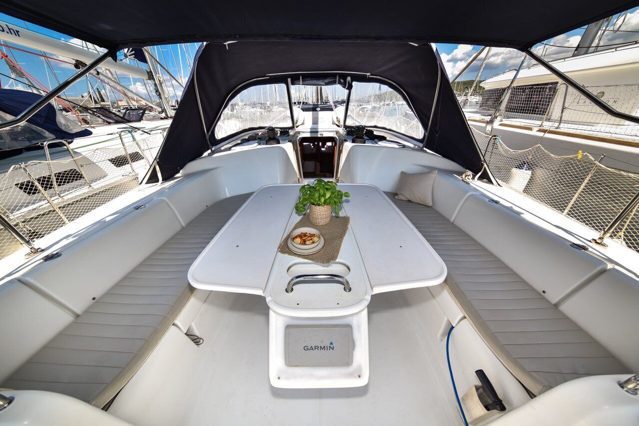 A boat's interior with a table, a Garmin device, and a view of other boats.