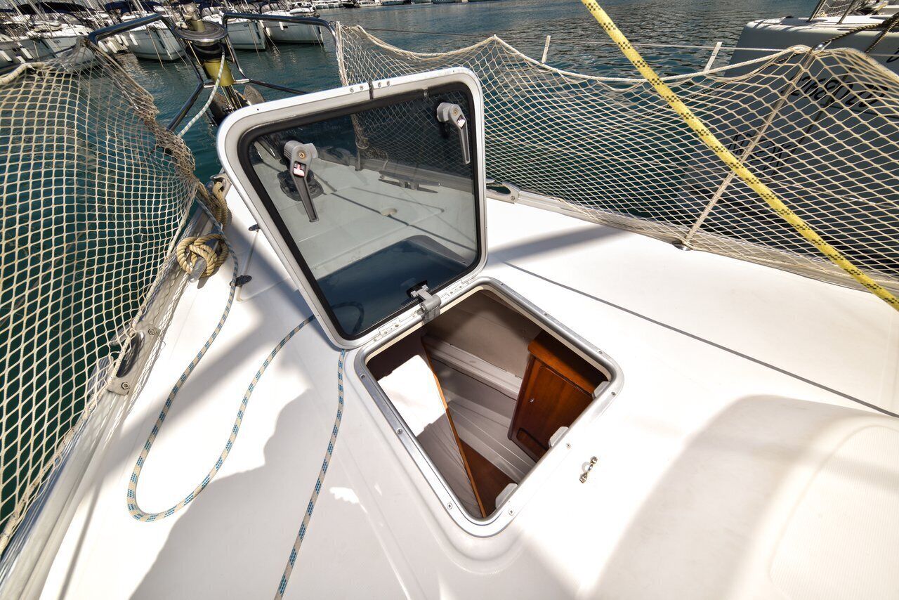 A boat's deck with a netted area, a small window, and a wooden cabin door.