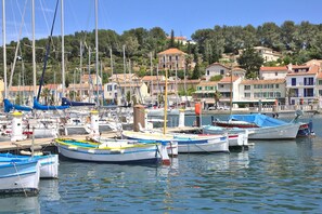 Un puerto deportivo con barcos amarrados, rodeado de edificios con techos de tejas rojas.