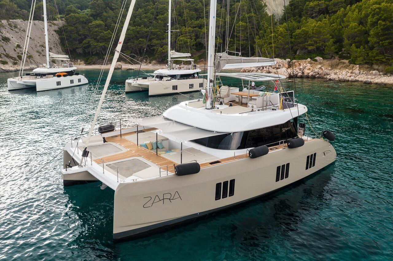 Un yacht baptisé « ZARA » était amarré dans une marina, aux côtés d’autres yachts, entouré d’eaux calmes et d’une végétation luxuriante.