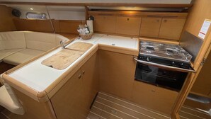 Une petite cuisine fonctionnelle équipée d’un évier, d’une cuisinière et de placards de rangement.