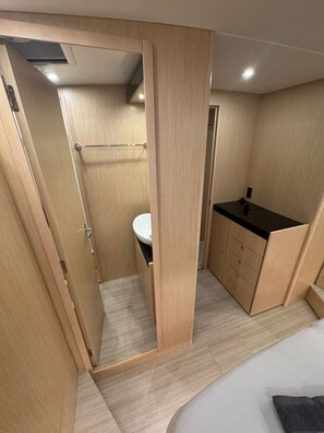 Une salle de bain moderne et compacte, équipée d’une douche, de toilettes et d’un lavabo.