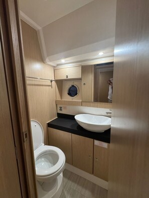 Une petite salle de bain comprenant des toilettes, un lavabo et un miroir.