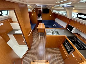 A compact galley with a sink, stove, and seating area. - Sun-Kissed Sailing Adventure in Zadar, Croatia (Bibinje)