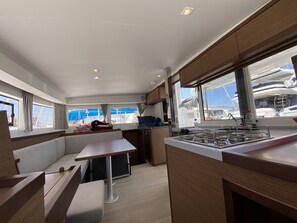 Una cocina moderna con comedor, ventanas amplias y vista a barcos.