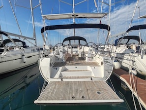 A marina with multiple sailboats docked, featuring a wooden deck, steering wheel, and a covered area. - Sun-Kissed Sailing Adventure in Zadar, Croatia (Drage)