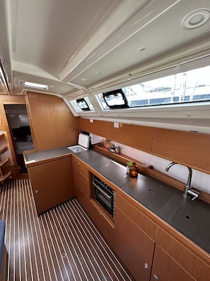 A compact galley with a sink, stove, and storage cabinets. - Sun-Kissed Sailing Adventure in Zadar, Croatia (Drage)