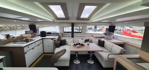 A boat interior with a kitchen, dining area, and seating. - Sun-Kissed Sailing Adventure in Zadar, Croatia (Zadar)