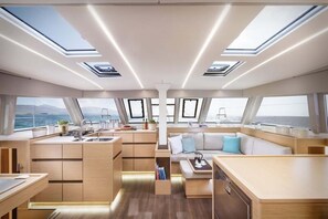 Ein modernes Yacht-Interieur mit Küche, Essbereich und Sitzgelegenheiten.
