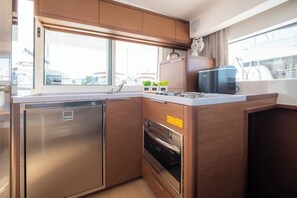 Uma cozinha compacta com geladeira embutida, forno e janela com vista para o exterior.