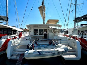 A marina with boats docked, including a white boat with 'HIGHFIELD' and 'YOU' on the bow.