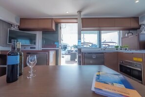 Eine moderne Küche mit Holzausstattung, einer Weinflasche und einem Glas auf der Arbeitsplatte.