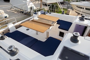 A boat deck with a wooden table, cushioned seating, and a small sink. - Sibenik Sun-soaked Sailing: A Luxurious Croatian Voyage (Pirovac)