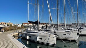A marina with multiple yachts docked, a clear sky, and buildings in the background. - Sibenik Sun-soaked Sailing: A Luxurious Croatian Voyage (Pirovac)
