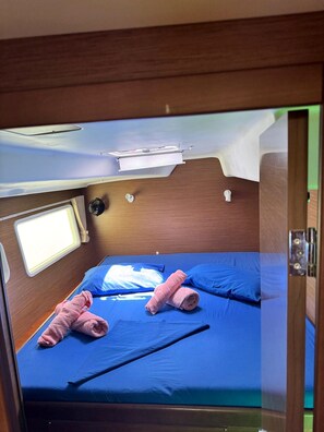 A compact room with a bed, two pillows, and a window.