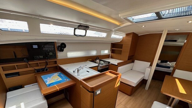 A compact galley with a sink, stove, and seating area. - Dubrovnik Delight: A Sun-Kissed Sailing Experience (Komolac)
