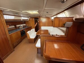 Schiffsinnenraum mit Kombüse, Sitzbereich und einem Garmin Navigationsgerät.