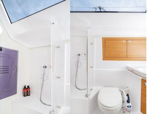 Ein modernes Badezimmer mit Dusche, Toilette und Holzschrank.