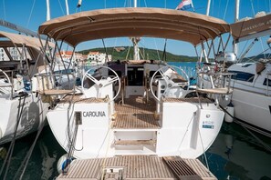 A marina with boats docked, including one named 'CAROLINA' with a wooden deck and a covered area. - Sibenik Sun-soaked Sailing: A Luxurious Croatian Voyage (Pirovac)