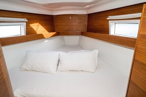A compact cabin with a bed, two windows, and wooden paneling. - Sibenik Sun-soaked Sailing: A Luxurious Croatian Voyage (Pirovac)