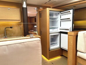 A compact kitchenette with a built-in refrigerator, a sink, and a countertop. - Sibenik Sun-soaked Sailing: A Luxurious Croatian Voyage (Pirovac)