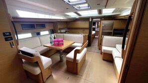 A compact, well-lit interior with a dining area, seating, and a kitchenette. - Sibenik Sun-soaked Sailing: A Luxurious Croatian Voyage (Pirovac)