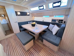 A compact interior with a dining area, seating, and a control panel. - Sun-Kissed Sailing Adventure in Istria, Croatia (Pula)