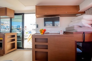 A compact kitchenette with a built-in oven, a small countertop, and a window overlooking a construction site.