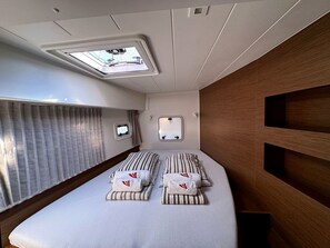 A compact room with a bed, a window, and a mirror.