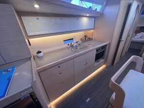 A compact kitchen with a built-in oven, a sink, and a small countertop area. - Sun-Kissed Sailing Adventure in Istria, Croatia (Pula)