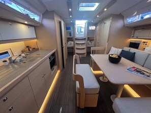 A compact, well-lit interior with a kitchenette, dining area, and seating.