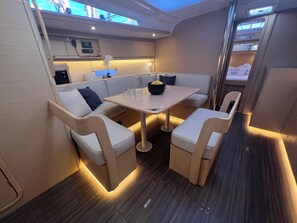 A compact, modern interior with a dining area, cushioned seating, and a small kitchenette. - Sun-Kissed Sailing Adventure in Istria, Croatia (Pula)