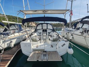 A marina with multiple sailboats docked, a clear sky, and a hilly landscape in the background. - Sun-Kissed Sailing Adventure in Zadar, Croatia (Drage)