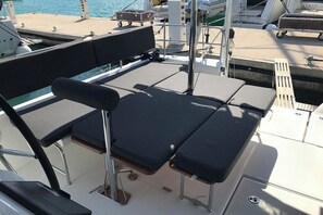 A boat deck with a seating area featuring cushioned chairs and a table. - Sun-kissed Sailing Adventure in Split-Dalmatia, Croatia (Seget Donji)
