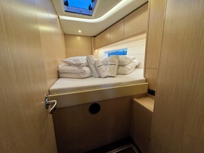 Ein kleines Badezimmer mit Duschkabine, kleinem Fenster und Handtuchhalter mit Handtüchern.