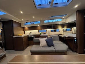 A compact, well-lit interior with a kitchenette, seating area, and skylights. - Sun-Kissed Sailing Adventure in Istria, Croatia (Pula)