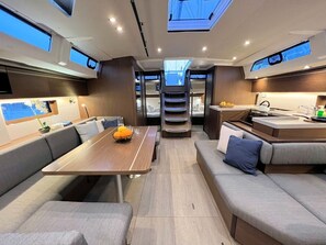 A modern interior with a dining area, seating, and a kitchen. - Sun-Kissed Sailing Adventure in Istria, Croatia (Pula)